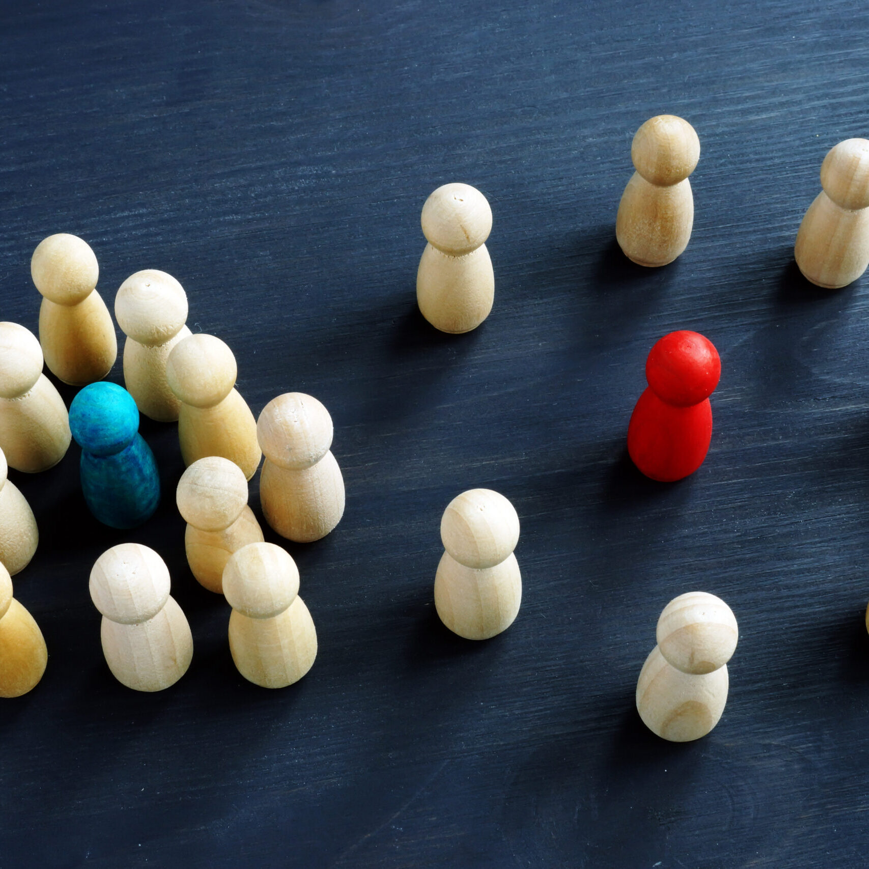 Introvert and extrovert concept. Wooden figurines on a desk.